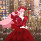 Belle, in a red dress made of flowers, sings to an adoring crowd while on top of a flying whale covered in speakers.